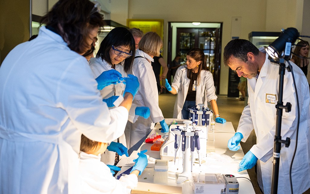 Participants working with pipettes and laboratory equipment during a PataFEST DNA testing workshop