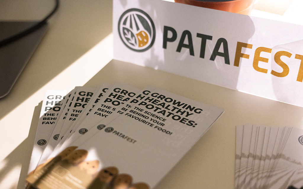 PataFEST brochures titled “Growing Healthy Potatoes: The Science Behind Your Favourite Food” displayed beside the project logo.